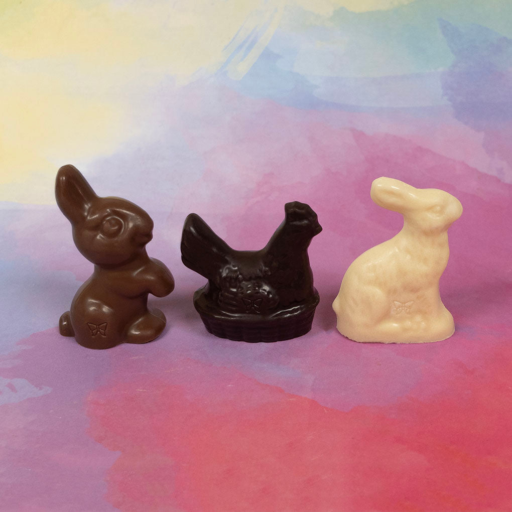 Three chocolate Easter animal figurines on a colorful background