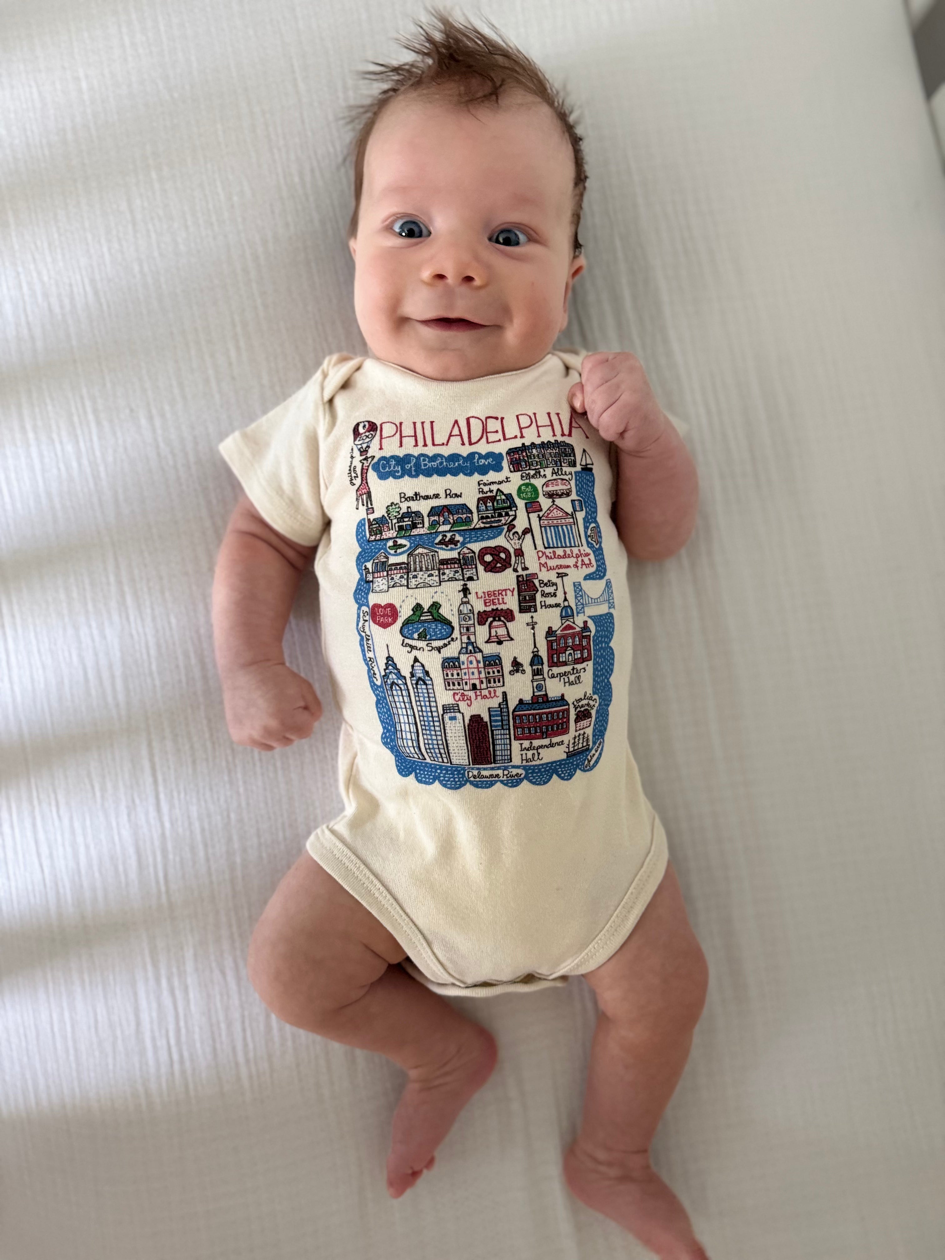 Baby wearing a onesie with 'Philadelphia' print on a white background