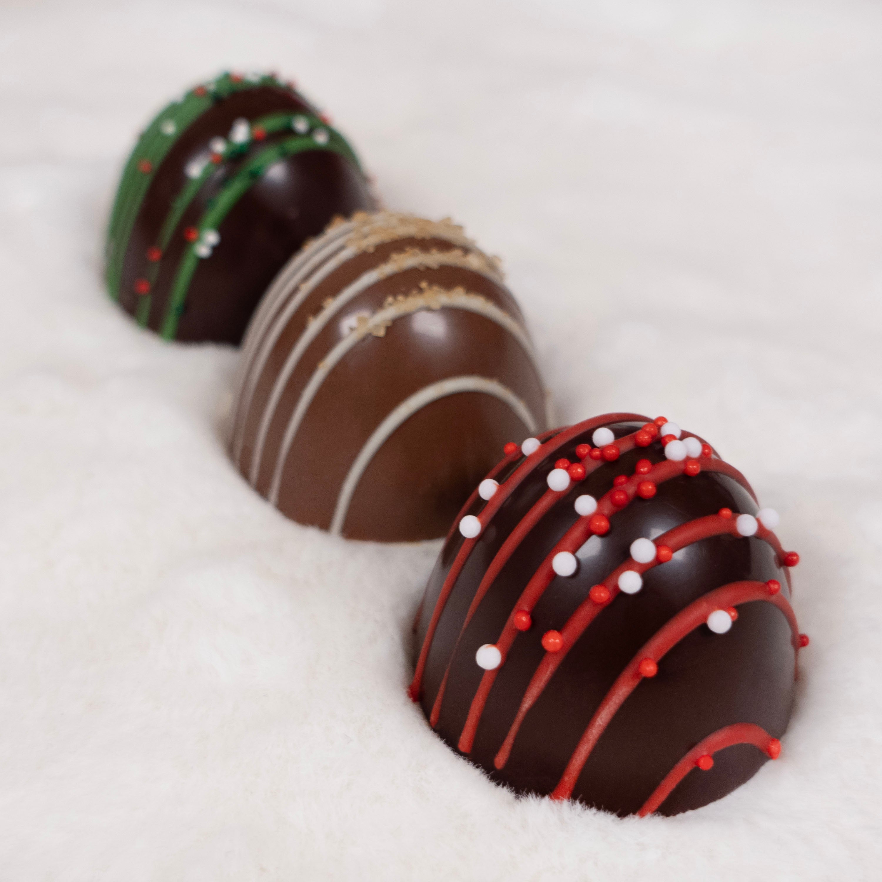 Three decorated chocolate truffles on a white background