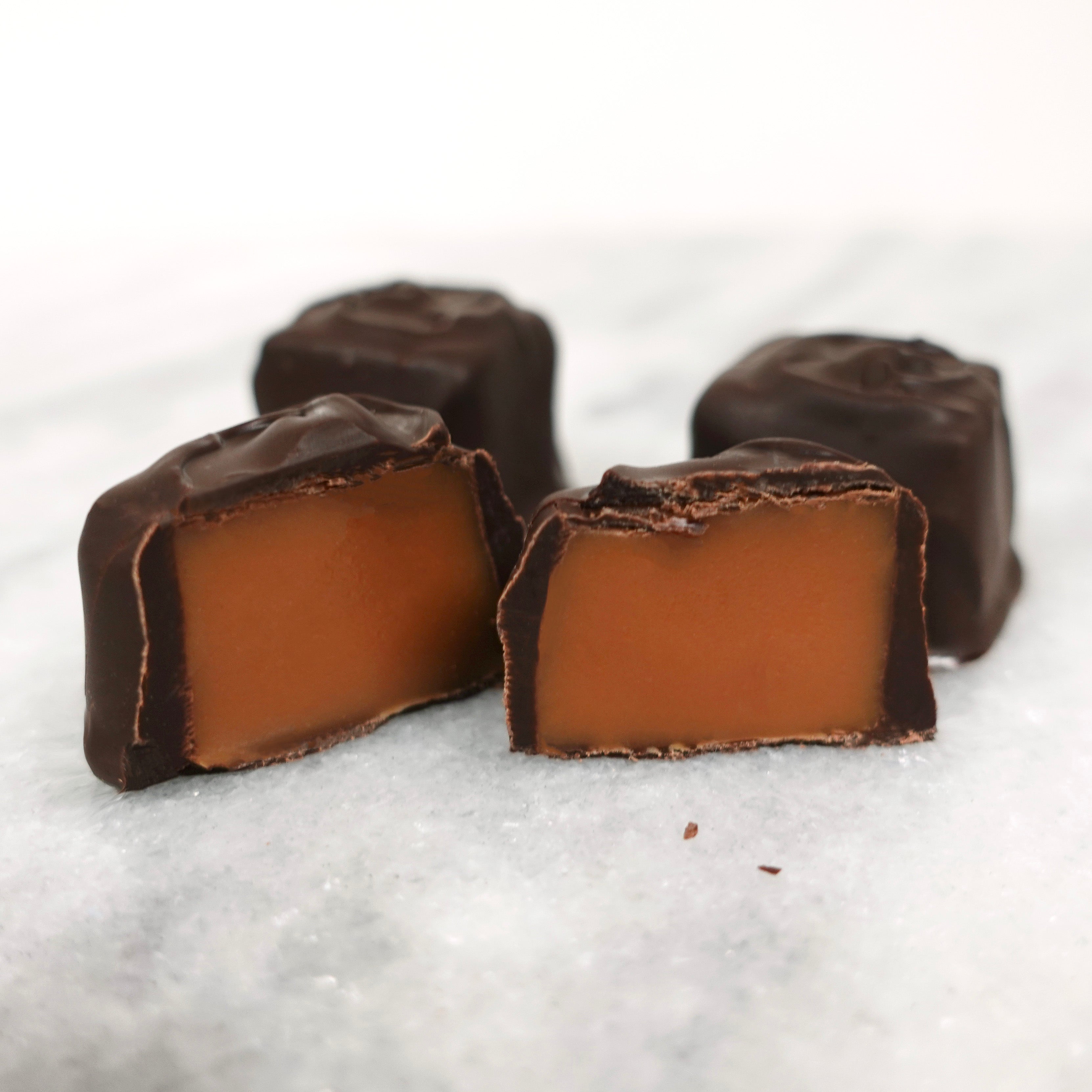 Chocolate-covered caramel candies on a white background