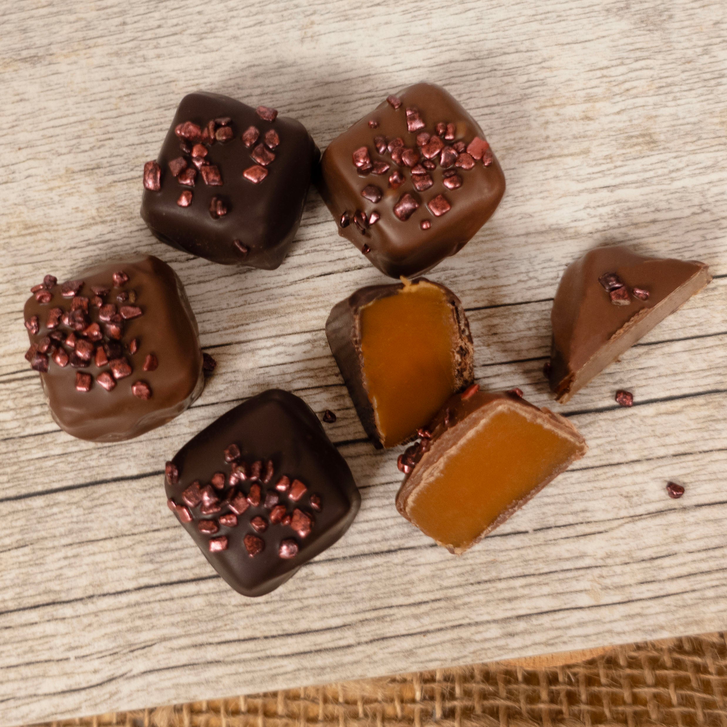 Assorted chocolate bergamot caramels on a wooden surface