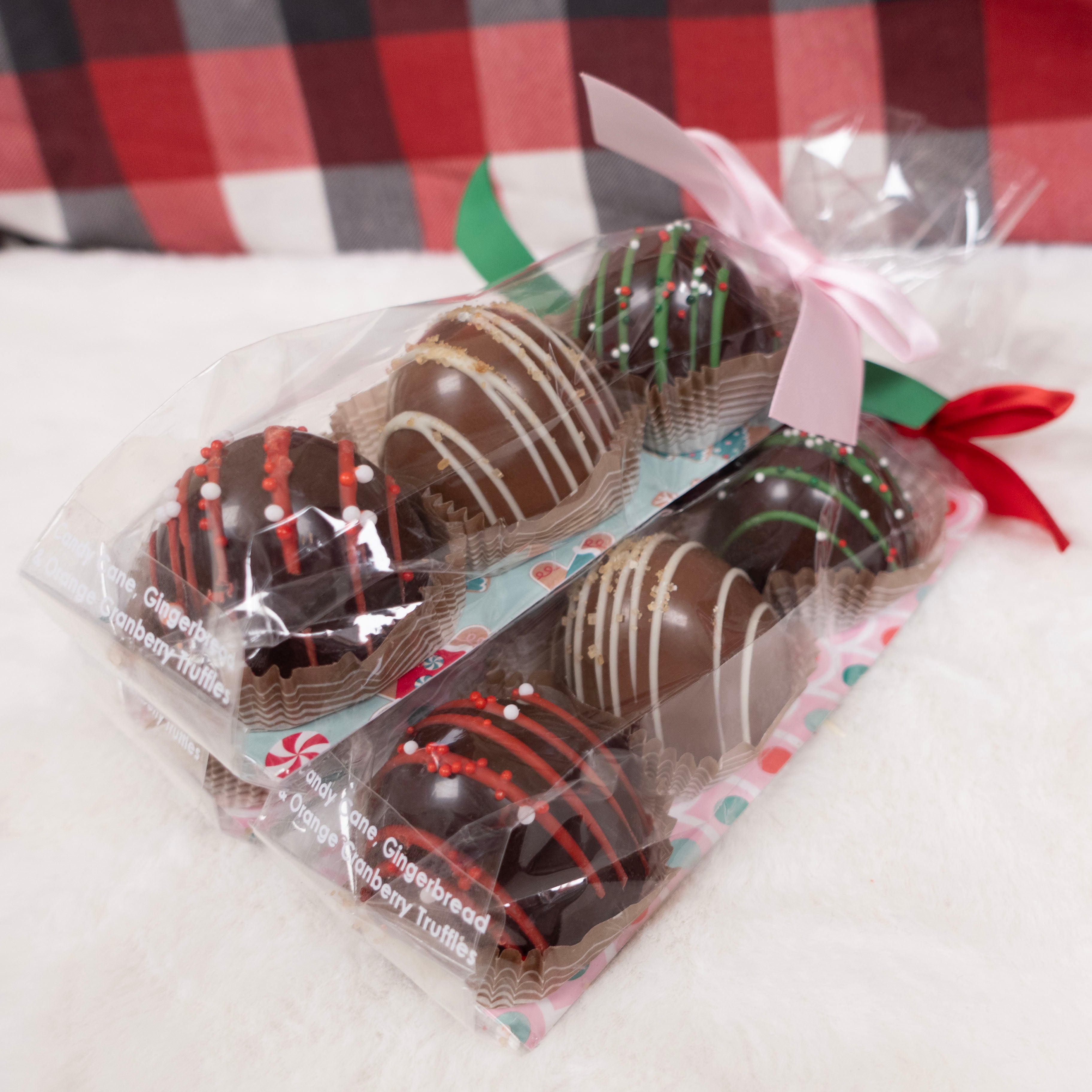 Packaged chocolate truffles with a red and green ribbon on a checkered background