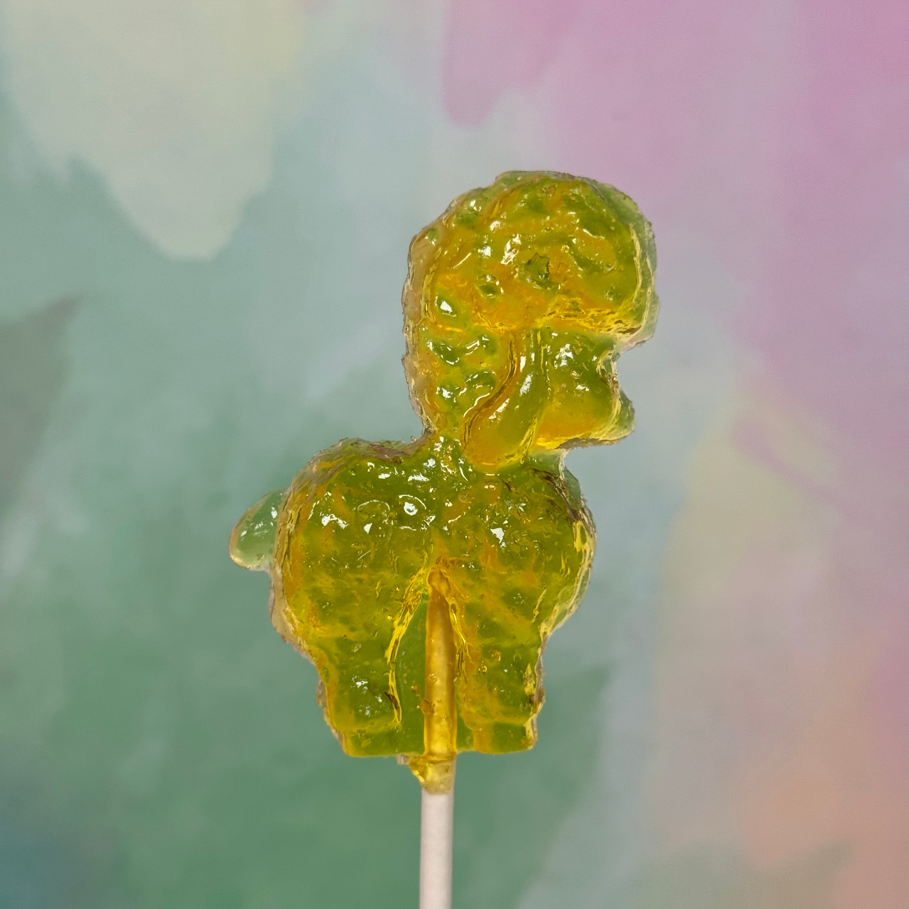 Yellow hard candy shaped like an Easter lamb on a stick against a blurred background
