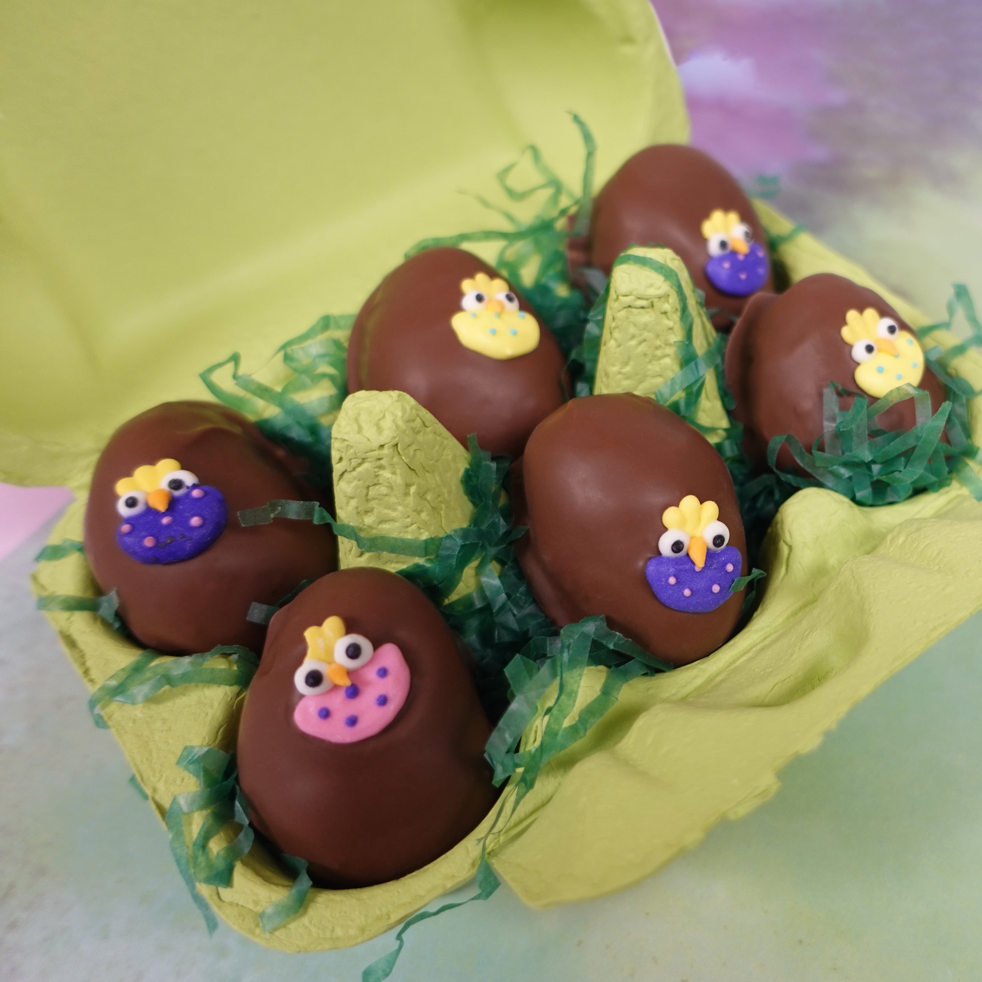 Green carton of milk chocolate coconut cream eggs with assorted easter chick decorations