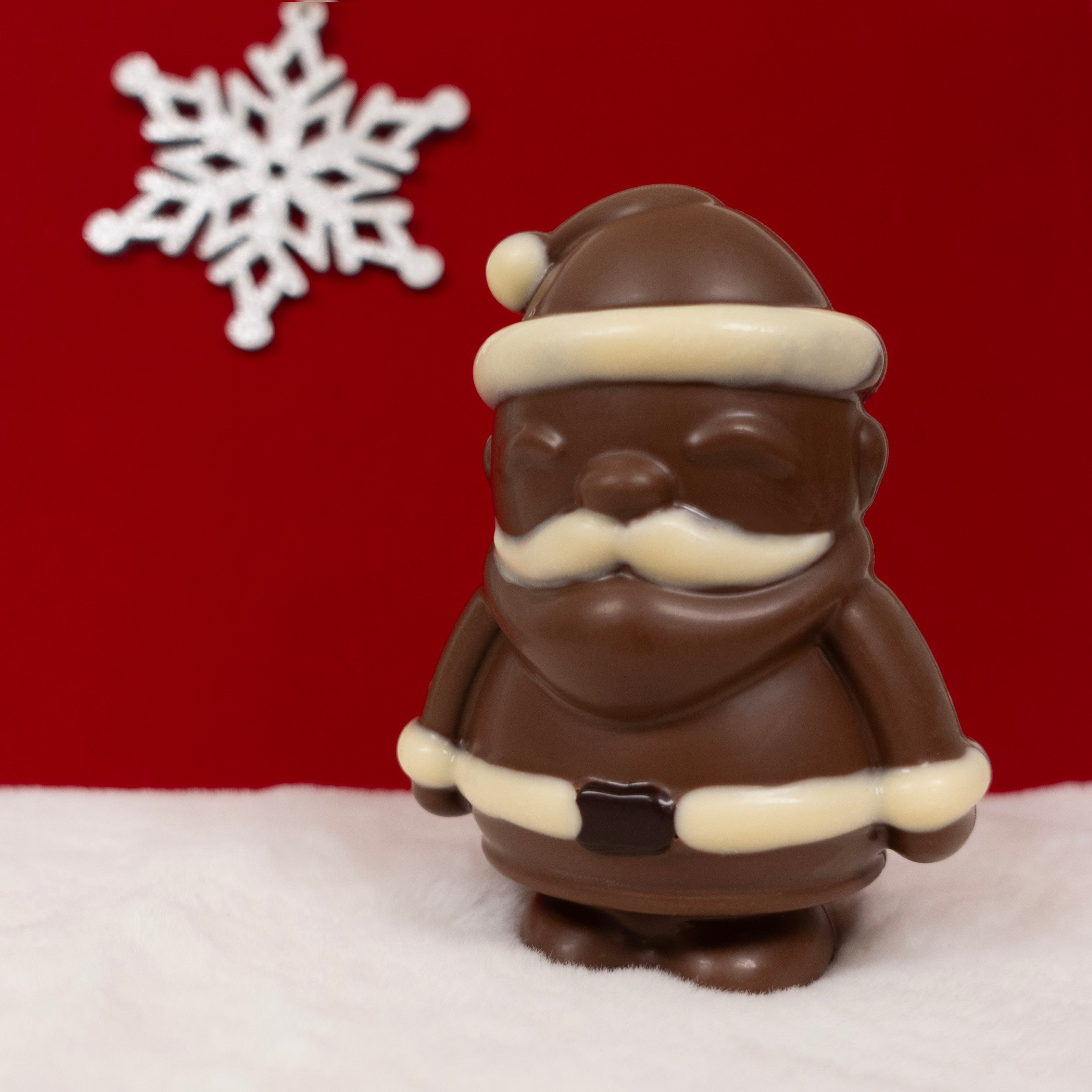 Chocolate Santa Claus figurine with a white snowflake on a red background