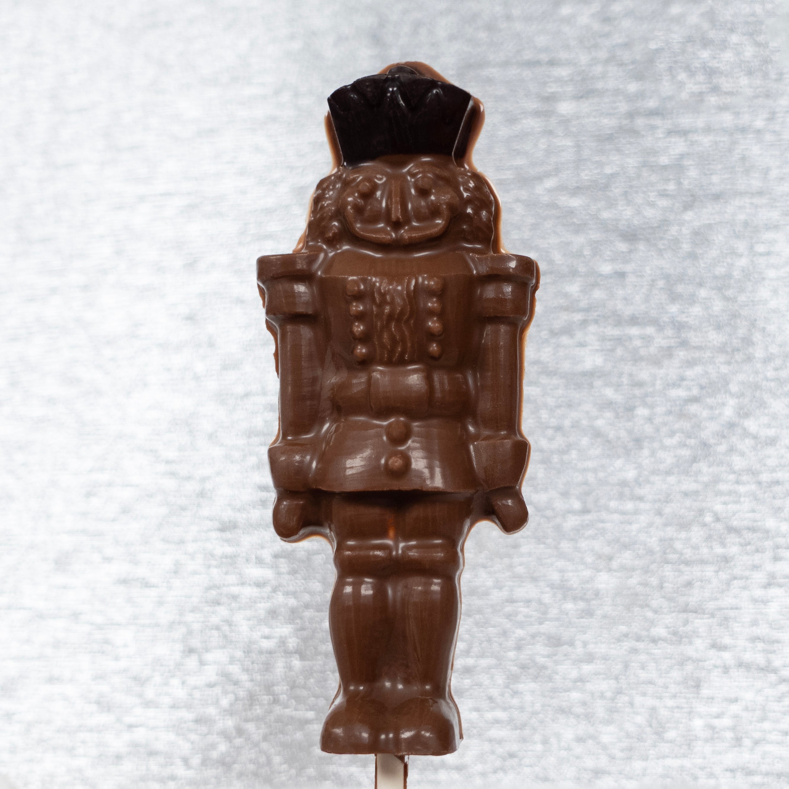 Christmas Chocolate figurine of a soldier nutcracker on a white textured background
