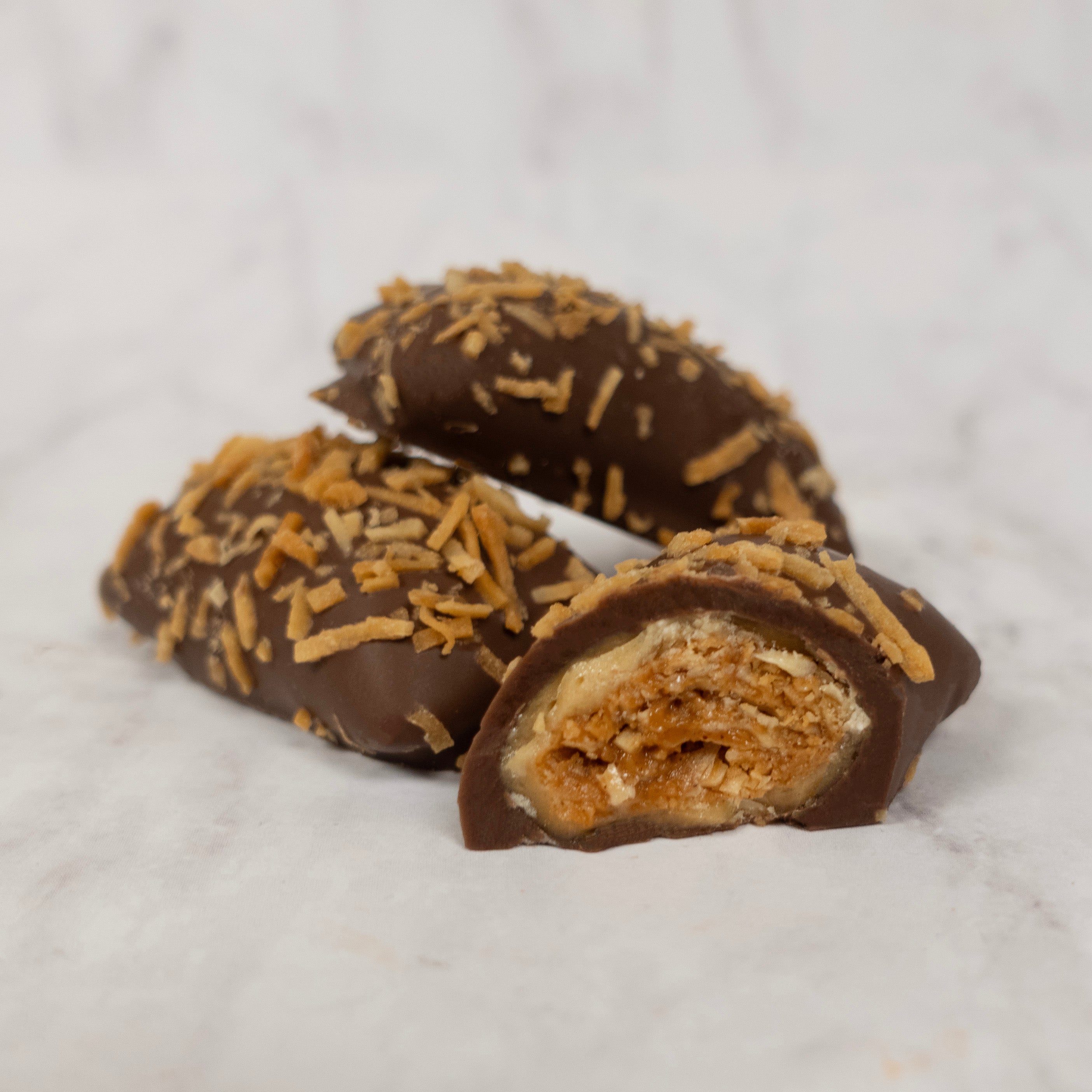 Peanutbutter candies covered with milk chocolate and shredded toasted coconut.