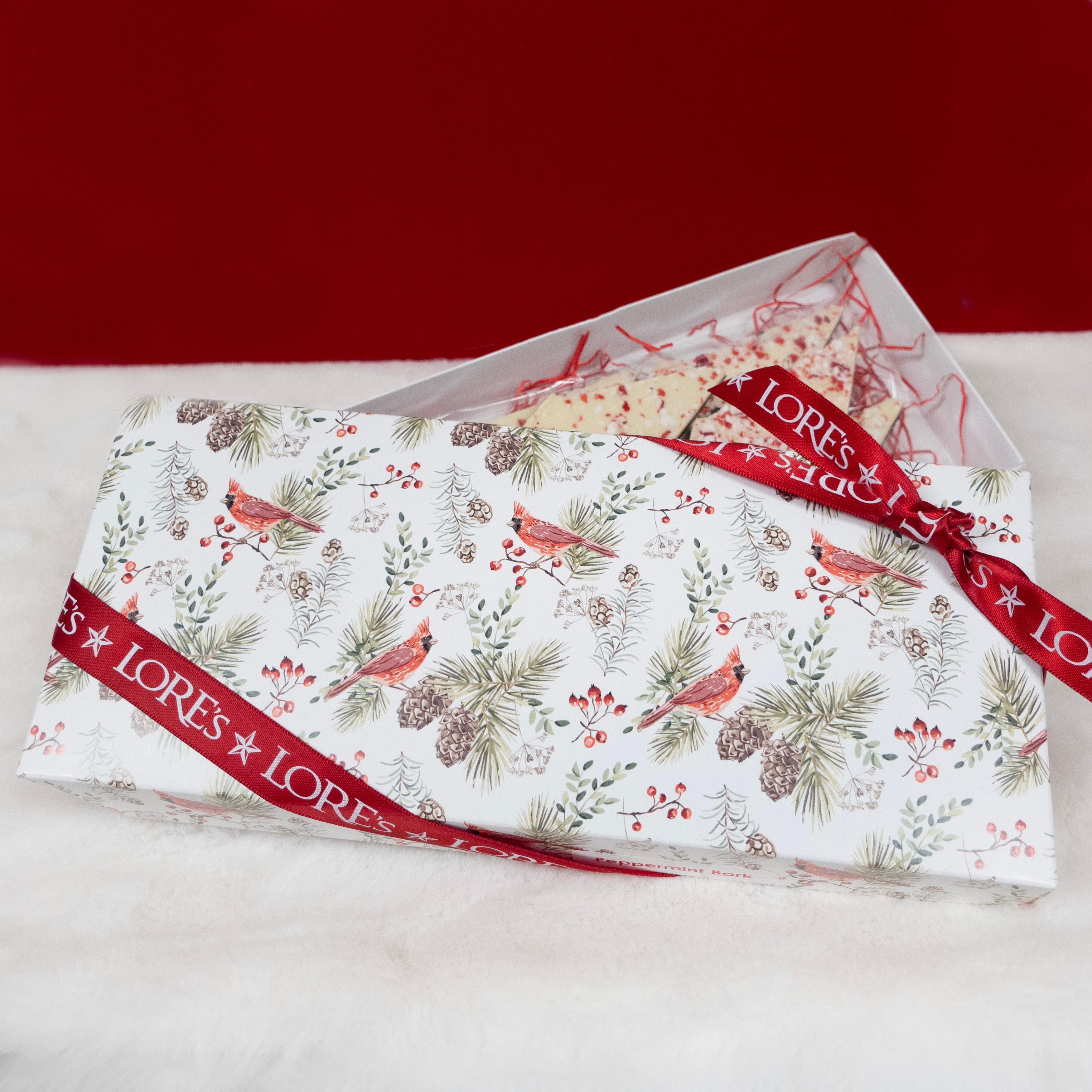 Packaged product with Christmas-themed design and 'LORES Chocolates' branding on a red background.