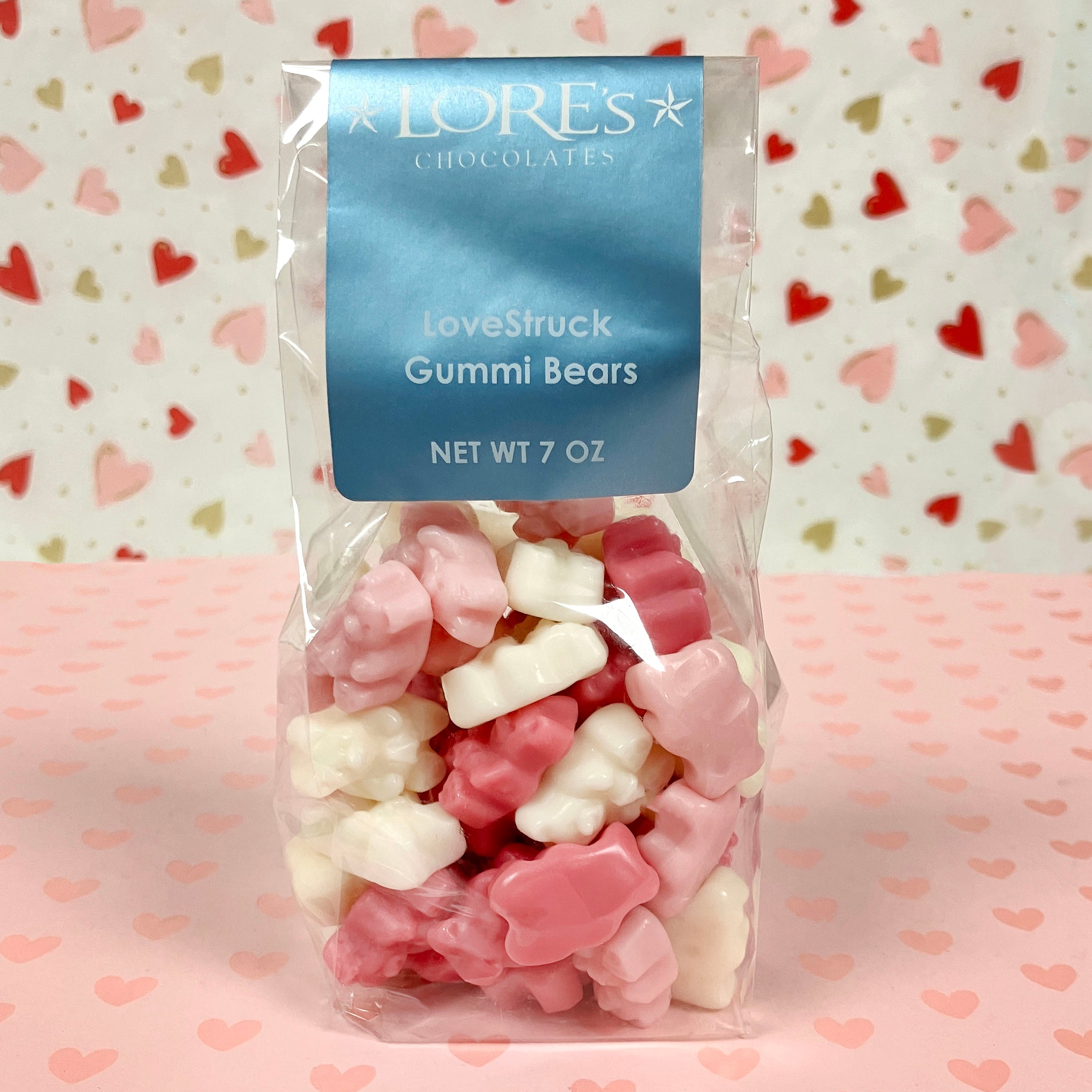 Packaged gummy bears with a blue label on a heart-patterned background for valnetine's day at Lore's Chocolates