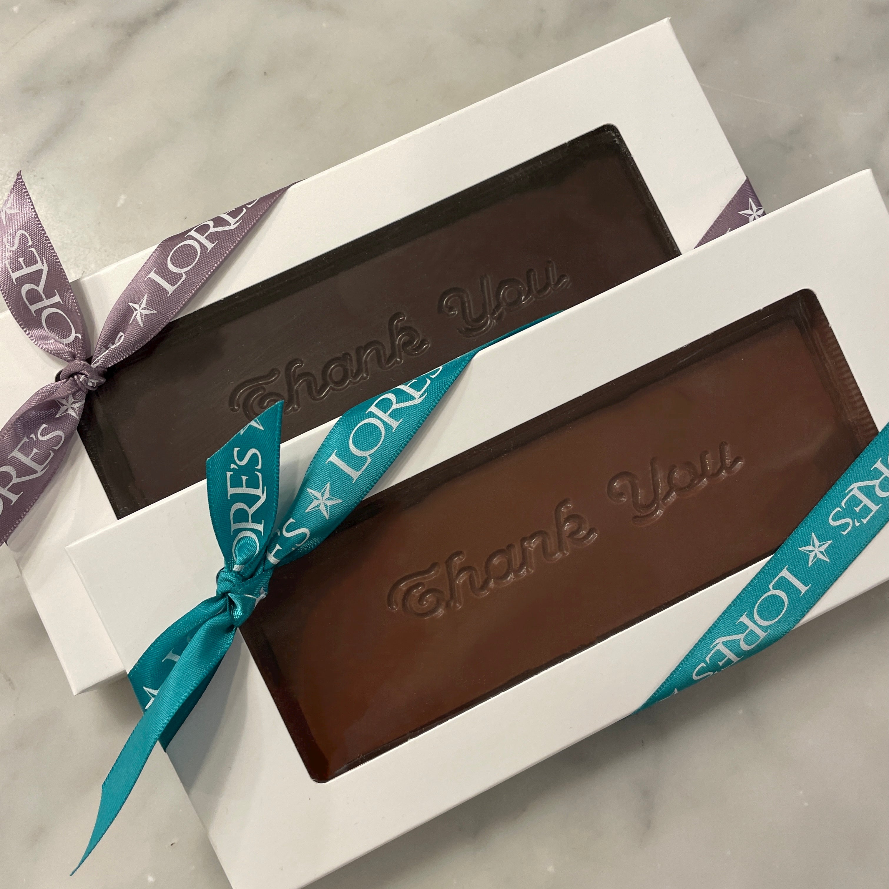 Thank you chocolate bars milk and dark from Lore's Chocolates. "Thank you" is inscribed on the chocolate