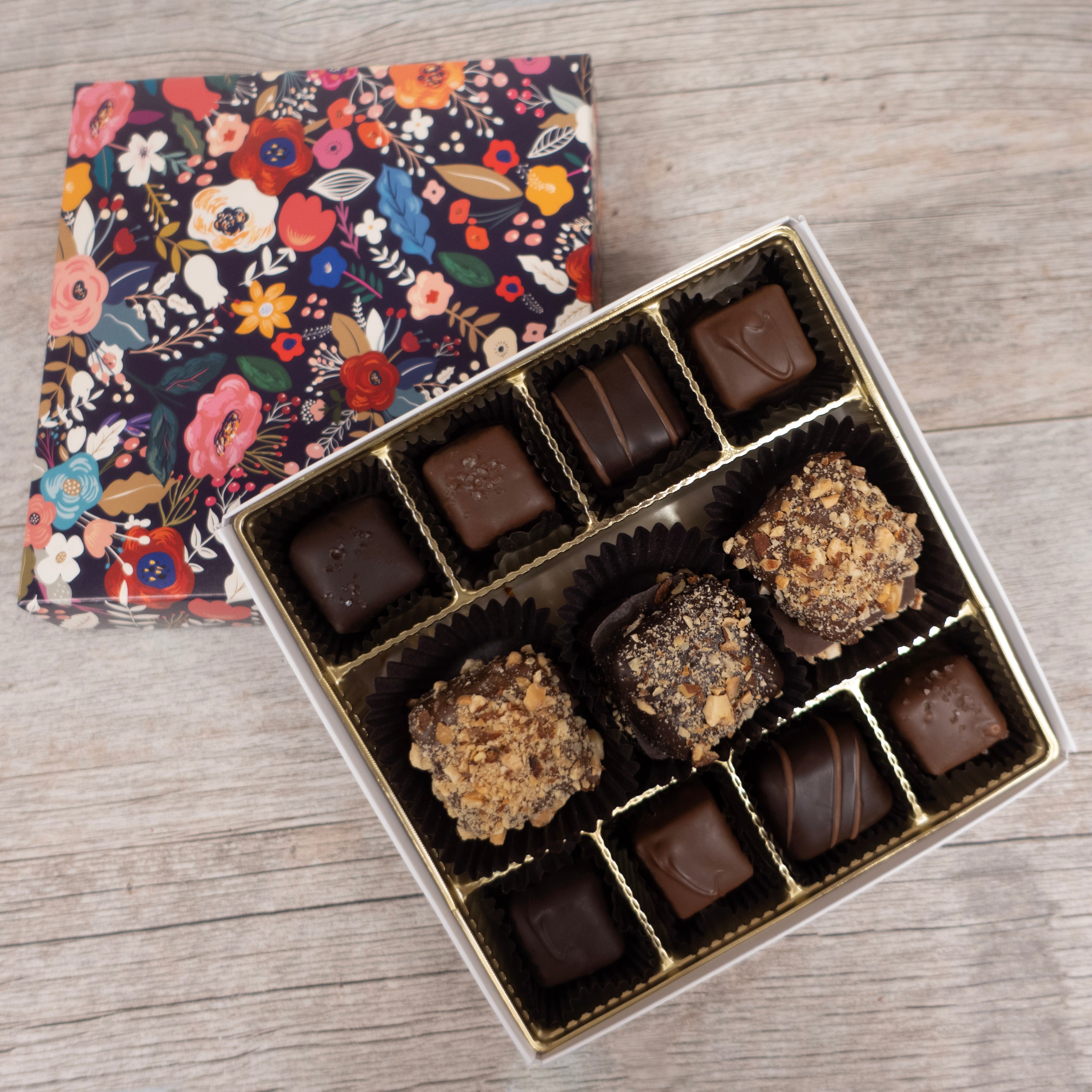 Box of chocolates with a floral-patterned box on a wooden surface