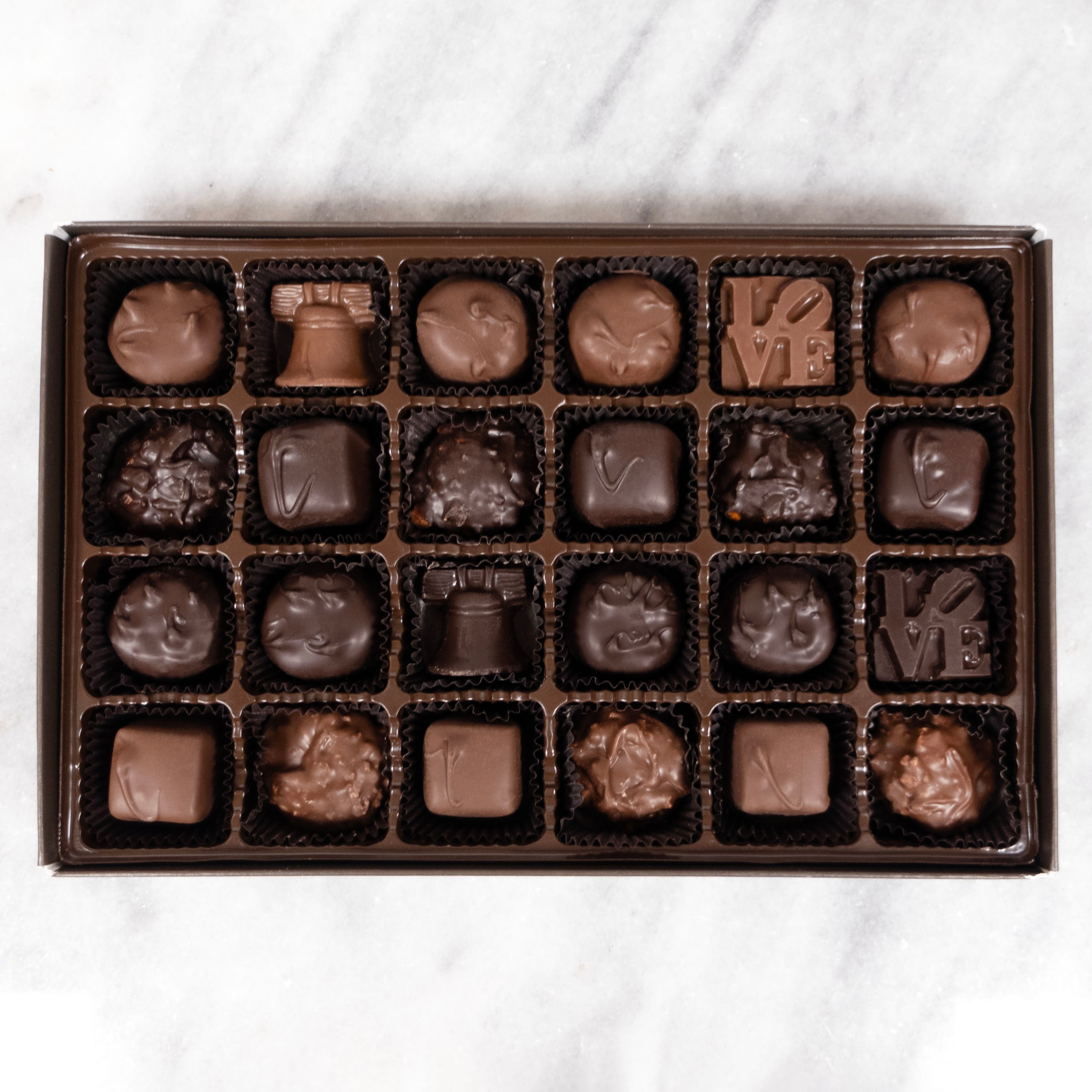 Box of assorted Philadelphia Lore's chocolates on a white marble surface