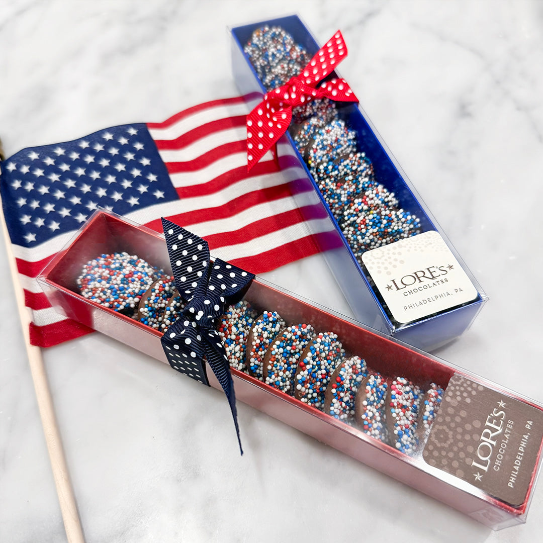Chocolate nonpareils with red, white, and blue patriotic jimmies/sprinkles in a box with an American flag and LORES Chocolates branding.