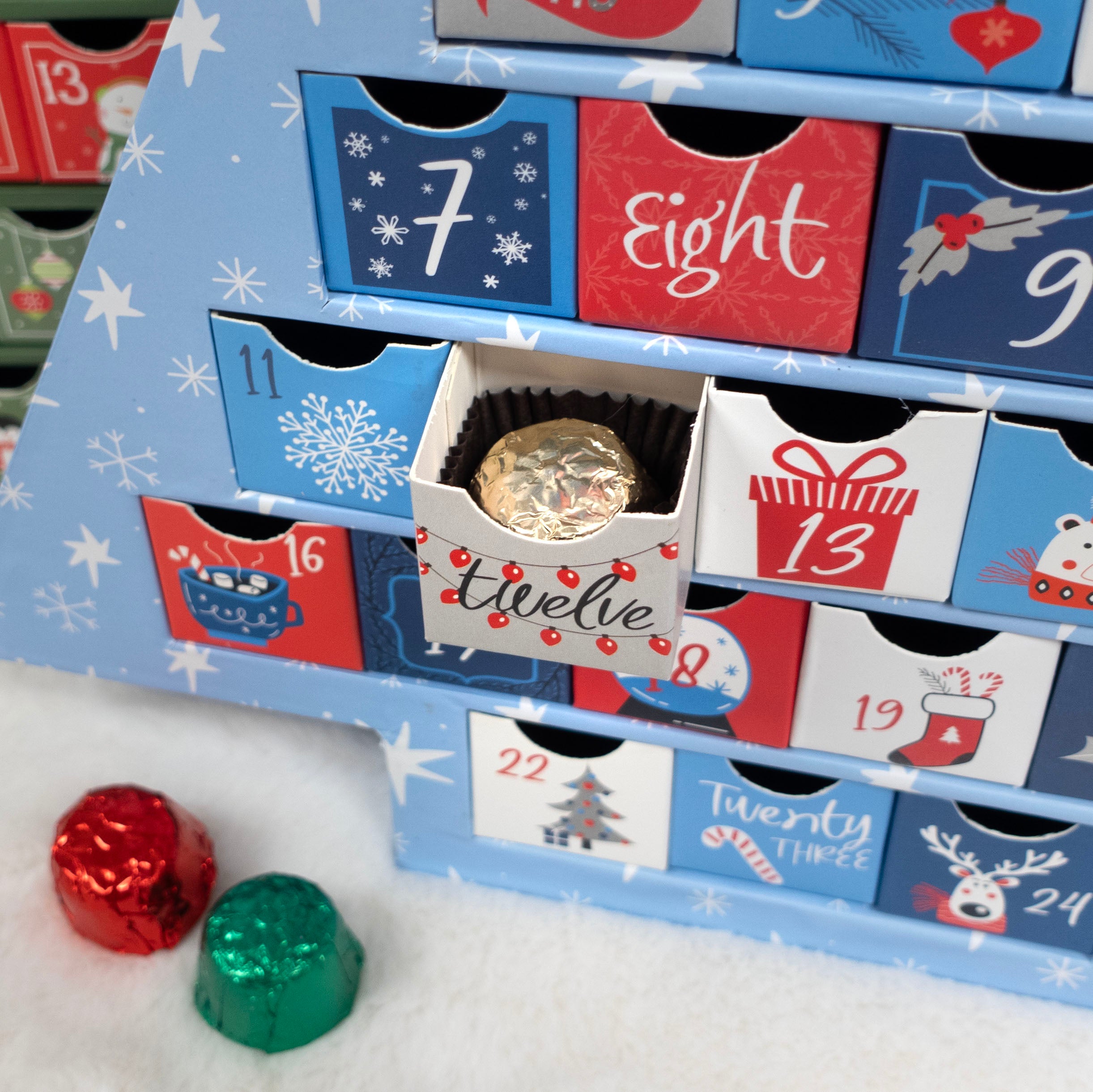  advent calendar with drawers labeled from 1 to 24, with some drawers open revealing chocolates.