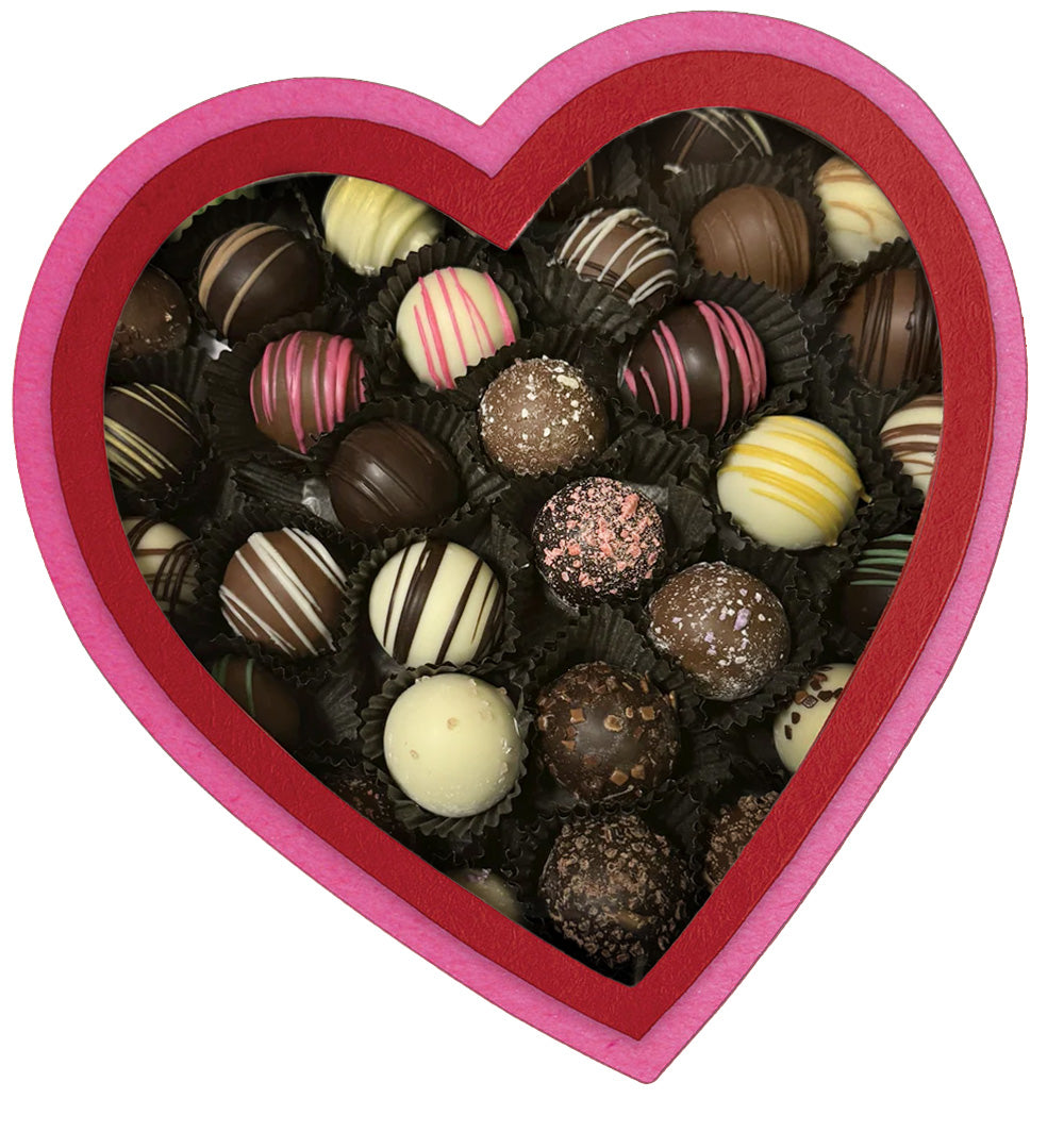 heart-shaped box with pink and red pleather, box is full of assorted artisan truffles from Lore's Chocolates 