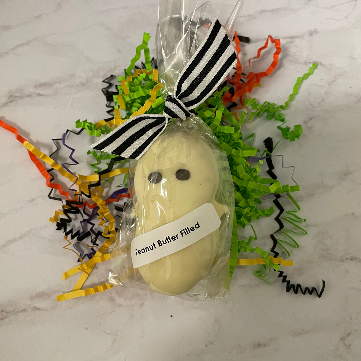 White chocolate coated nutter butter cookie - decorated like a ghost with dark chocolate eyes