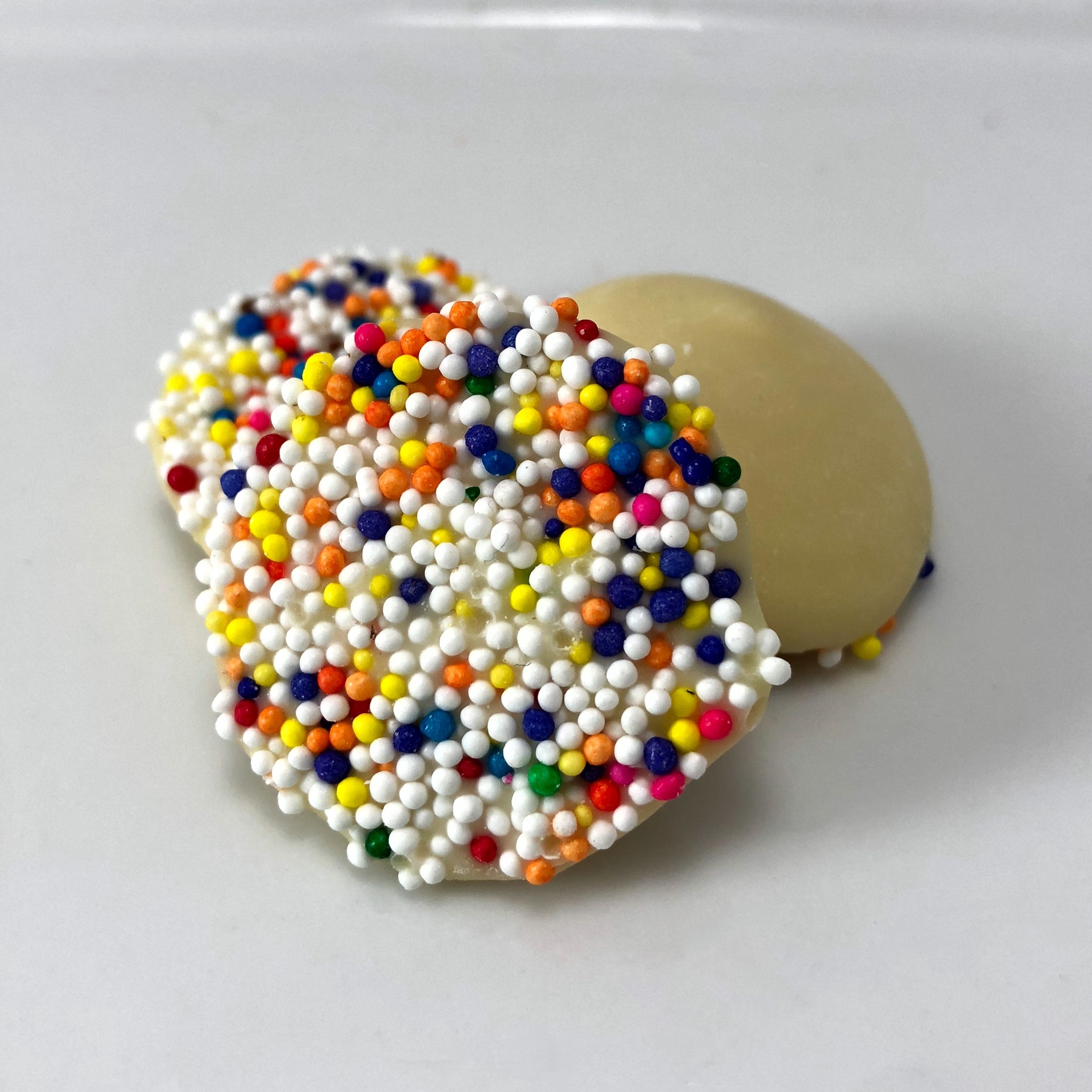 Creamy white chocolate buttons decorated with multi color seeds